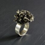 Контрастное фото кольца из меди и сплава с натуральным камнем на черном фоне